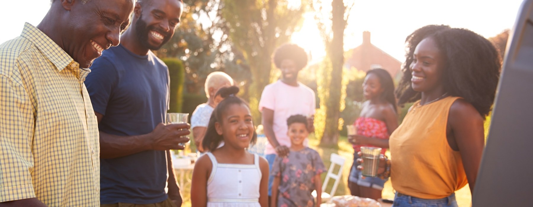 a group of people standing around a grill with food on it