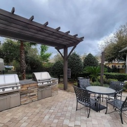 a grill area with a table and chairs